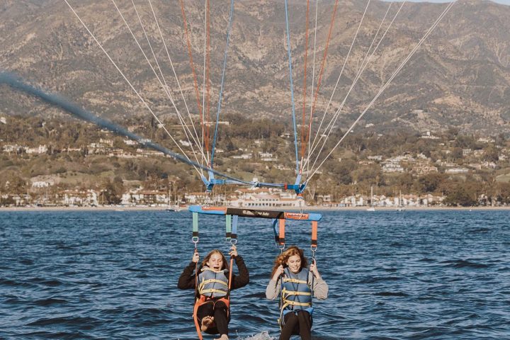 a man flying a kite in a large body of water